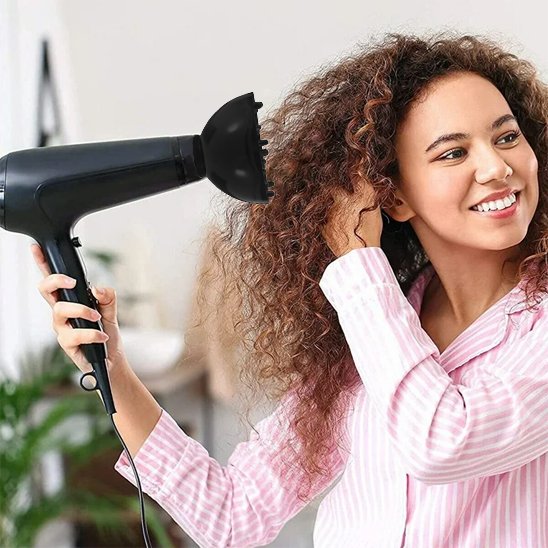 Femme cheveux boucles qui seche cheveux avec diffuseur noir