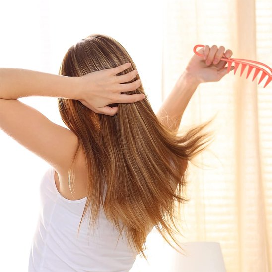 Femme se coiffe avec peigne rouge